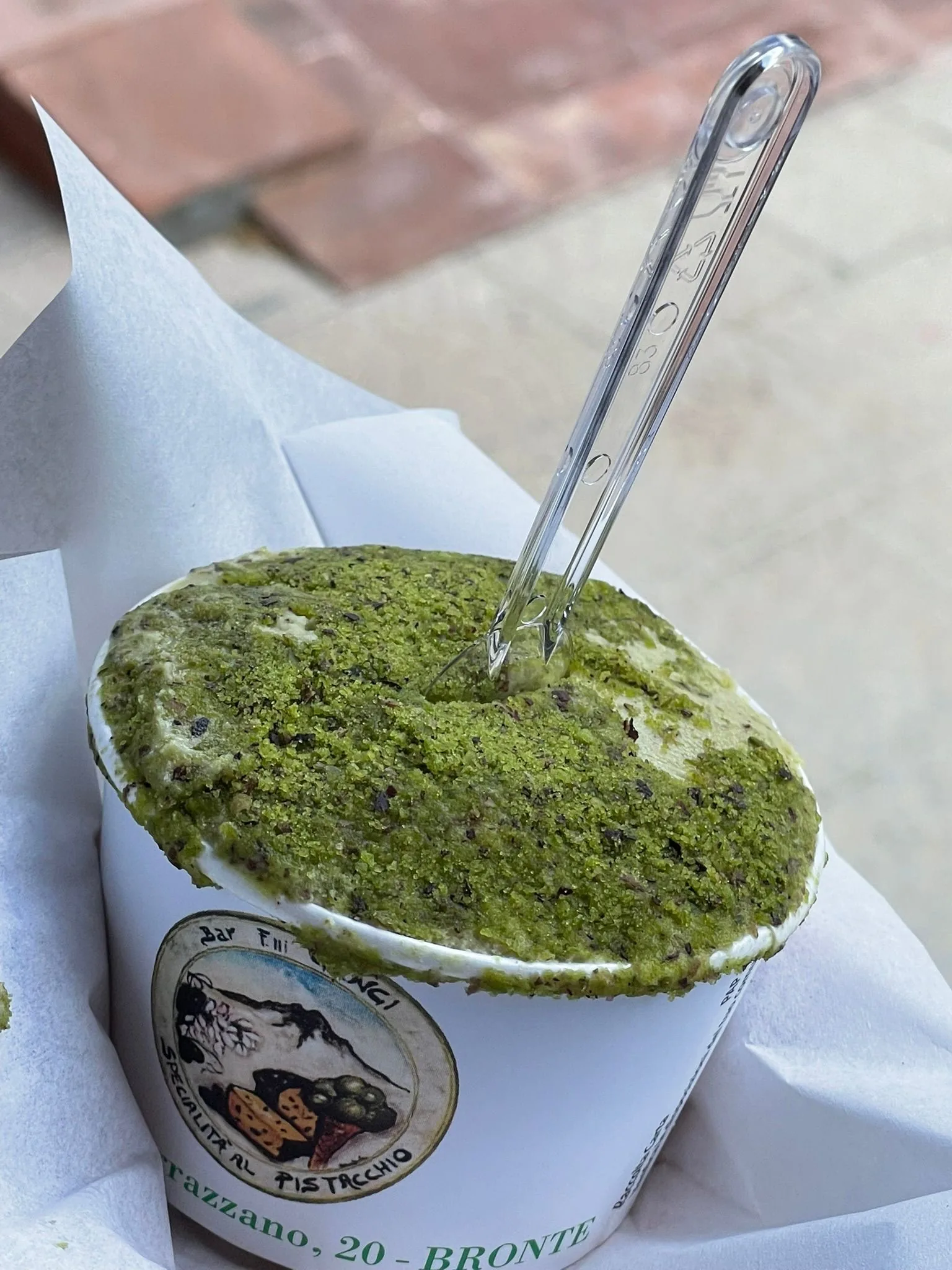 Sicilian pistachio gelato in a paper cup